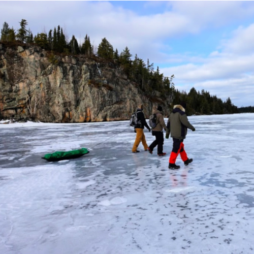 Ice fisherman walk past the Seagull Lake Palisade Cliffs in the Boundary Waters Canoe Area Wilderness